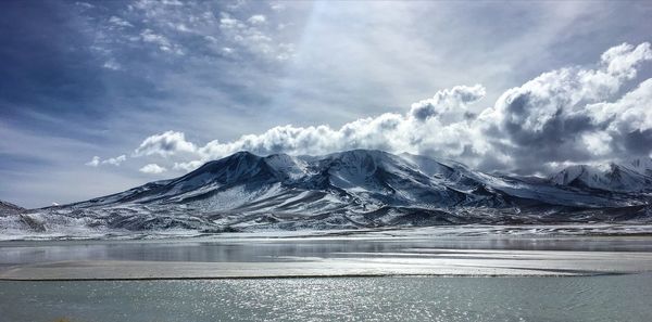 Scenic view of lake and snowcapped mountains against sky