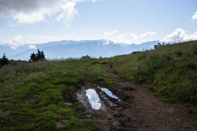 The sky and clouds are reflected in the pools of water on monte altissimo di nago in trento, italy