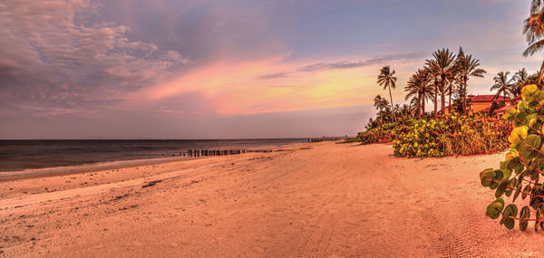 Old pier in the ocean at port royal beach at sunrise in naples, florida