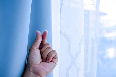 Cropped hand by window