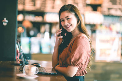 Portrait of smiling young woman standing outdoors