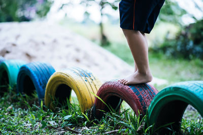 Low section of boy standing on tires at playground