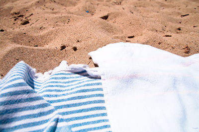 Low section of person relaxing on sand at beach