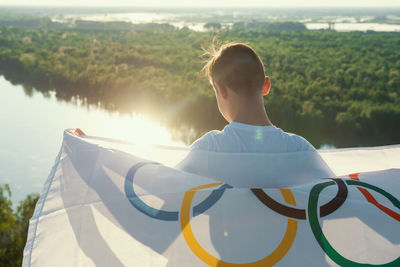 Rear view of boy holding flag