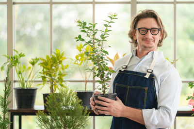 Man taking care of her potted plants at home, gardening, planting at home