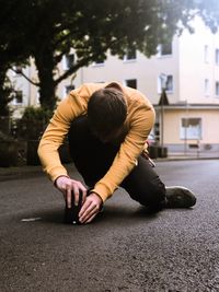 Rear view of man skateboarding on road