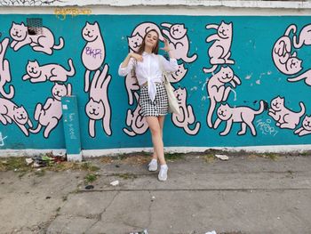 Woman standing against graffiti wall