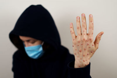 Close-up of human hand against wall