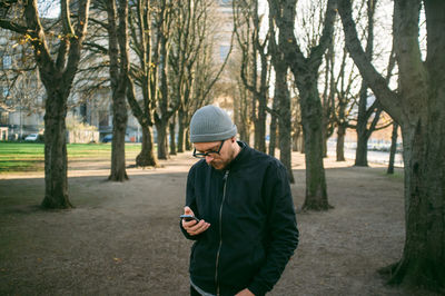 Mid adult man using phone in park