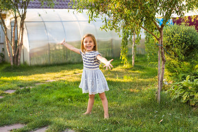 Full length of smiling girl on field