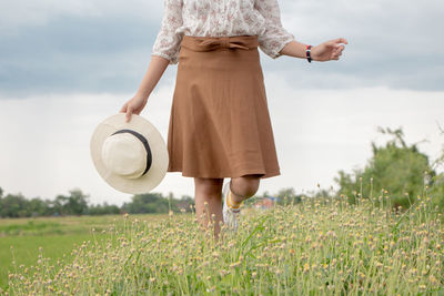 Woman standing on field against sky