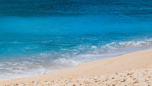 Scenic view of beach against blue sky