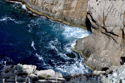 Close-up of rocks in sea against sky