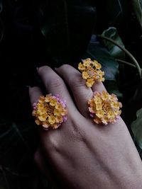 Close-up of hand holding yellow flowers