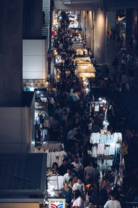 High angle view of crowd at street market during night