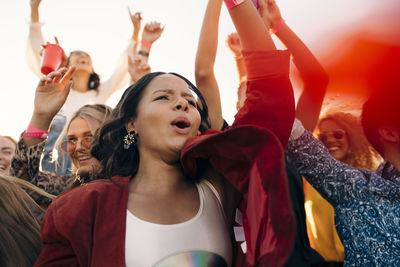 Happy men and women in audience enjoying at music concert