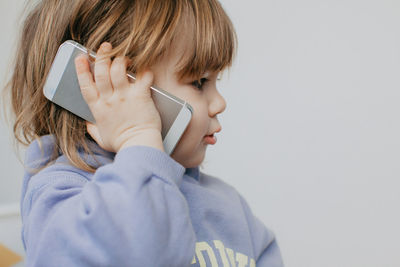 Young woman using mobile phone against white background