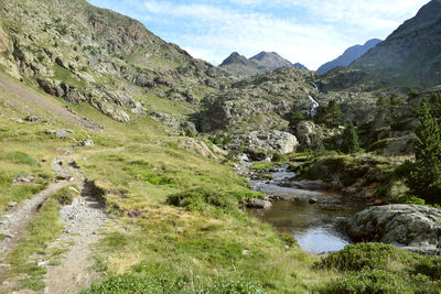 Scenic view of river by mountains against sky