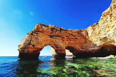 Scenic view of rock formation in sea against sky