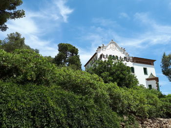Low angle view of trees and building against sky