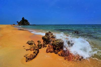 Scenic view of beach against blue sky