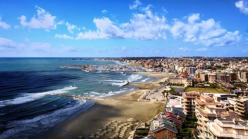 Aerial view of sea and buildings against sky