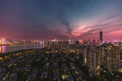 Illuminated city against sky at night