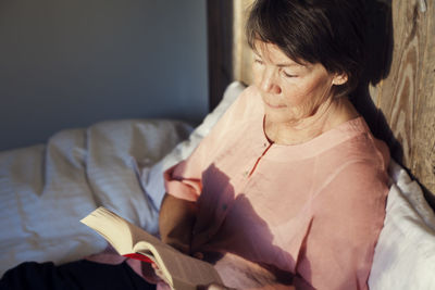 Senior woman reading book in bed