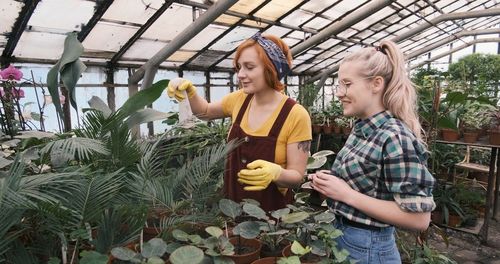 Happy woman standing in greenhouse