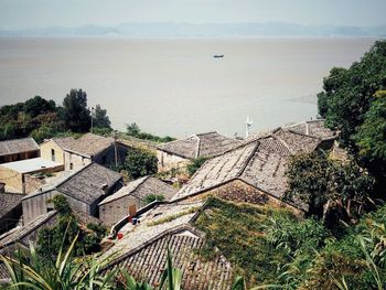 High angle view of townscape by sea against sky