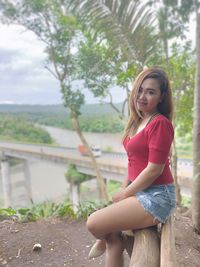 Portrait of woman standing against tree