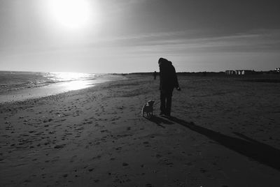 Silhouette man on beach against sky