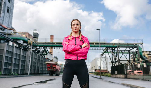 Confident woman with arms crossed standing on street