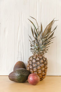 Close-up of apples in jar on table against wall