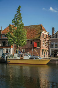 Buildings by river against sky in city