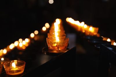 Close-up of lit tea light candles in church