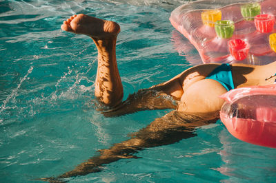 Low section of woman swimming in pool