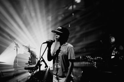 Side view of man standing on illuminated stage at night