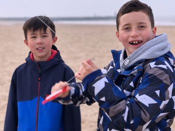 Portrait of boys standing on beach