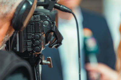 Camera at a media press conference publicity outdoors.