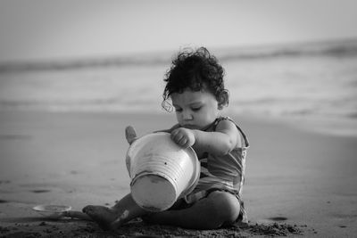 Girl sitting on shore at beach