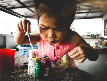 Portrait of cute girl looking at camera on table