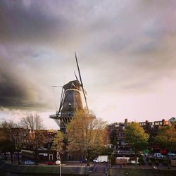 Traditional windmill against sky in city