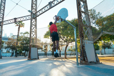 Rear view of man jumping on street