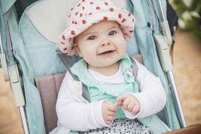 Portrait of cute baby girl sitting on sofa at home