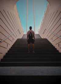 Rear view of man standing on staircase