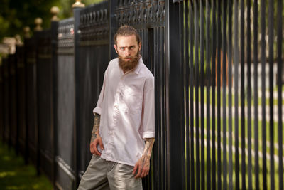 Portrait of young man standing against wall