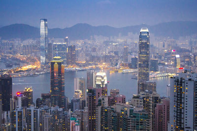 Illuminated buildings in city against sky