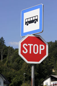 Low angle view of road sign against blue sky