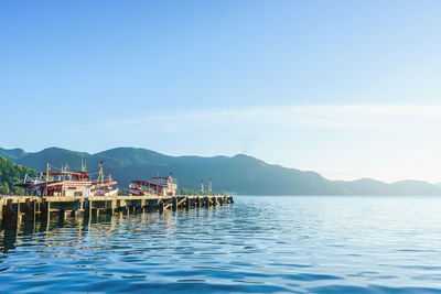 View of calm blue sea against mountain range